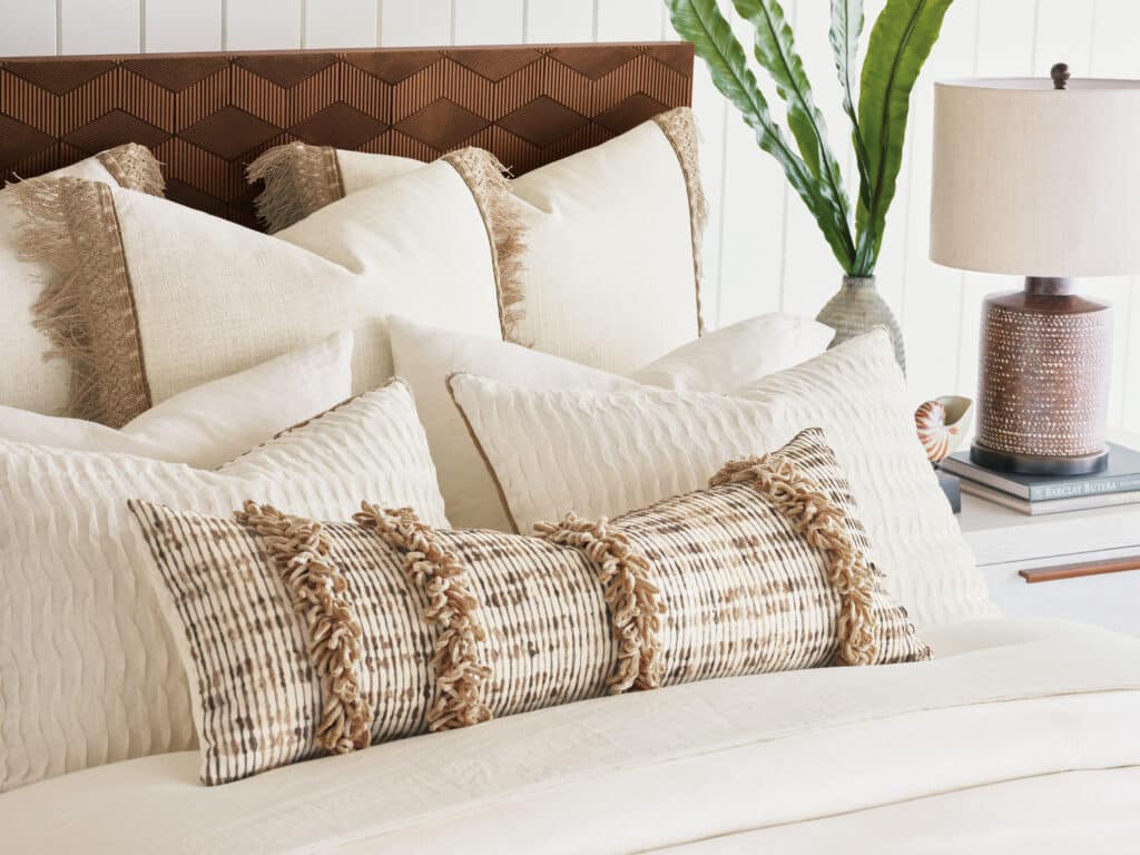 custom designed white and tan decorative pillows on bed