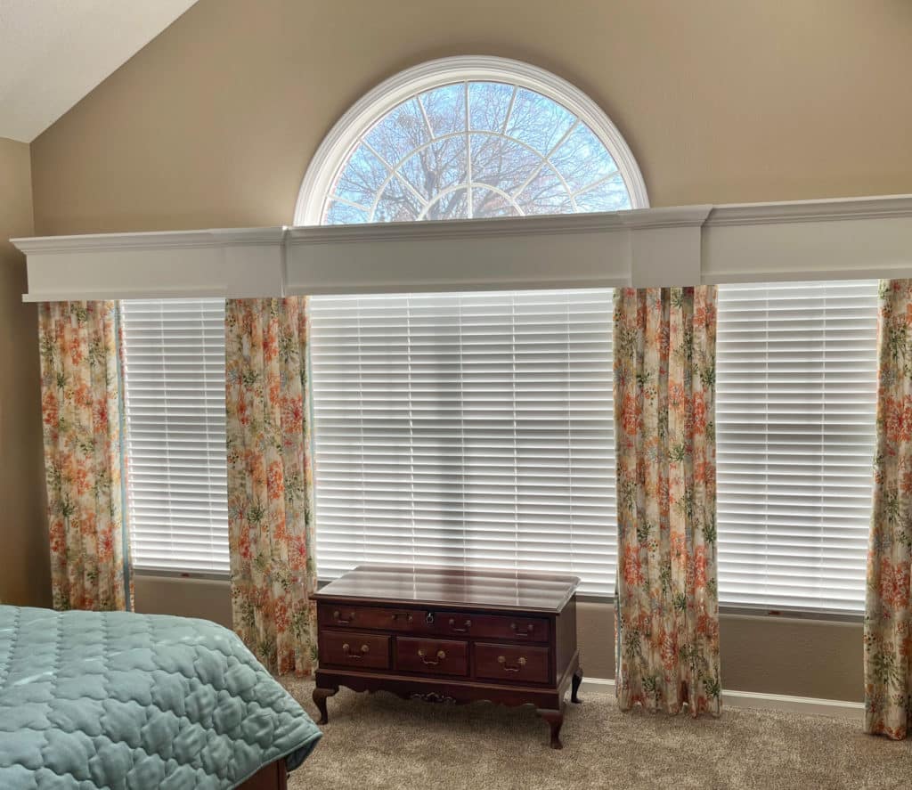 White wood cornices in a classy bedroom with floral curtains